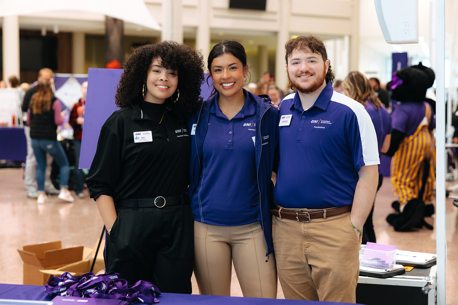 Admissions counselors and student staff smile welcomingly at camera