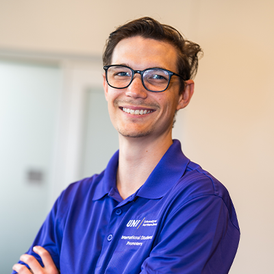 Curstin V. smiling in a purple UNI polo
