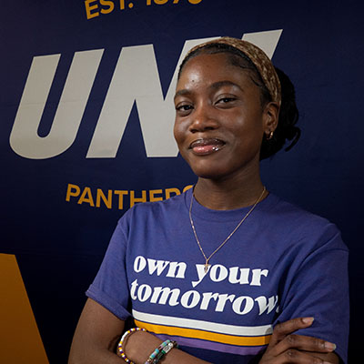 Ellen smiling in a purple t-shirt that reads "own your tomorrow."