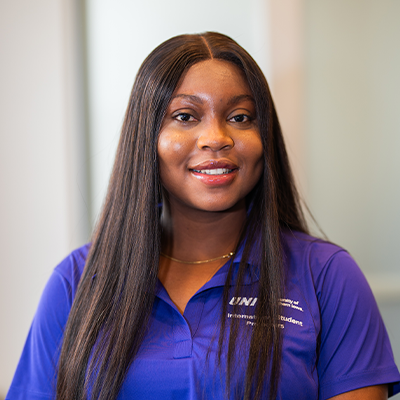 Faith O. smiling in a purple UNI polo