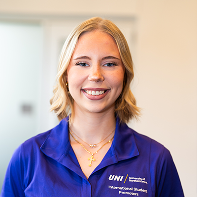 Fiona A. smiling in a purple UNI polo