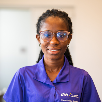 Harriet Q. smiling in a purple UNI polo