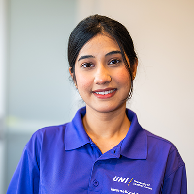 Hira R. smiling in a purple UNI polo