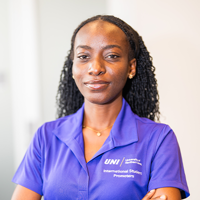 Ifeoluwa O. smiling in a purple UNI polo