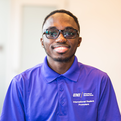 Ismael K. smiling in a purple UNI polo