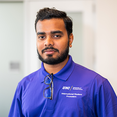 Jesan Z. smiling in a purple UNI polo