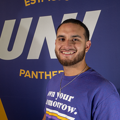 Jordan smiling in a purple t-shirt that reads "own your tomorrow."