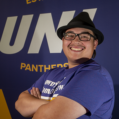 Lance smiling in a purple t-shirt that reads "own your tomorrow."