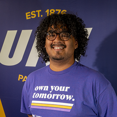 Martin smiling in a purple t-shirt that reads "own your tomorrow."