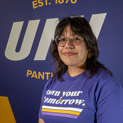 Miranda smiling in a purple t-shirt that reads "own your tomorrow."