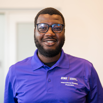 Nashiru M. smiling in a purple UNI polo