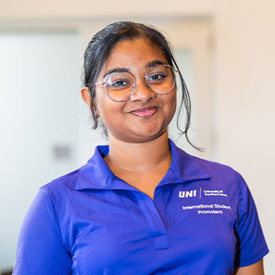 Niyola T. smiling in a purple UNI polo