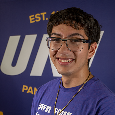 Robert smiling in a purple t-shirt that reads "own your tomorrow."