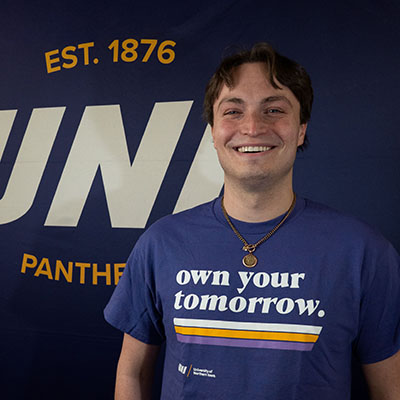 Will smiling in a purple t-shirt that reads "own your tomorrow."