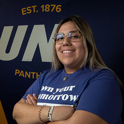 Yaretzi smiling in a purple t-shirt that reads "own your tomorrow."