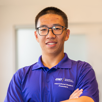 Yian S. smiling in a purple UNI polo