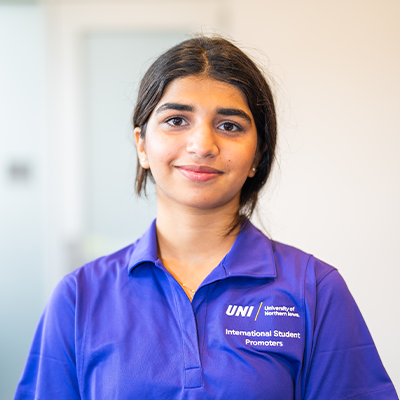 Zoha I. smiling in a purple UNI polo