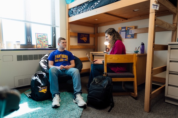 Two students studying in a dorm room.