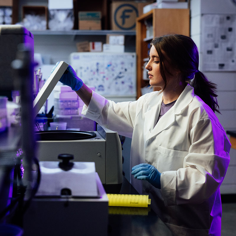 Female biochemistry student using lab equipment