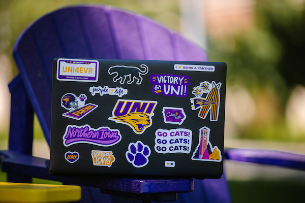 Close up of a laptop with UNI stickers.