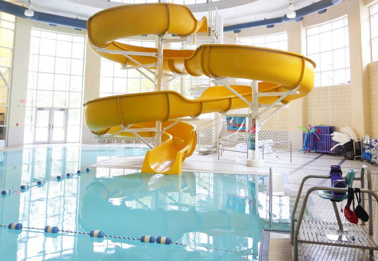 An indoor pool with a bright yellow slide